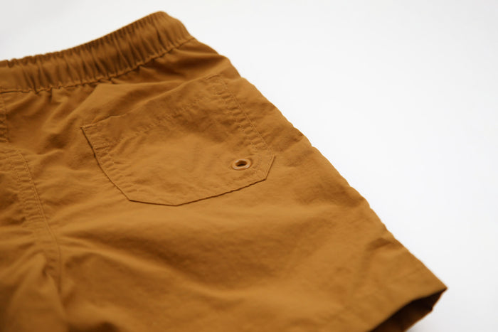 Close-up of quick-dry recycled polyester fabric – ginger swim trunks