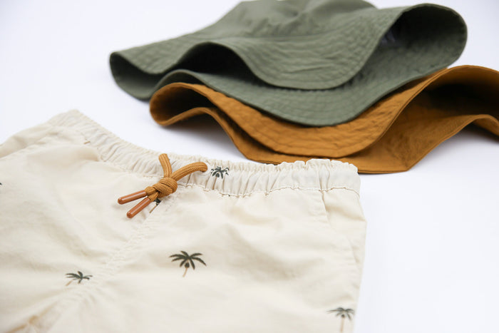 Close-up of quick-dry recycled nylon fabric – palm almond swim trunks