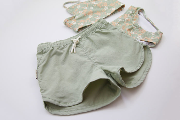 Close-up of quick-dry sage green fabric – girls swim trunks