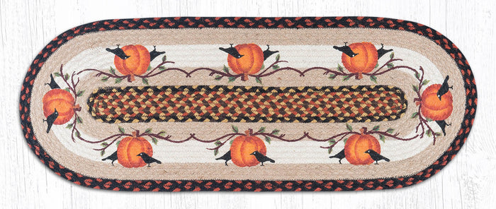 Decorative table runner with pumpkins and crows on a tan background made from braided jute.