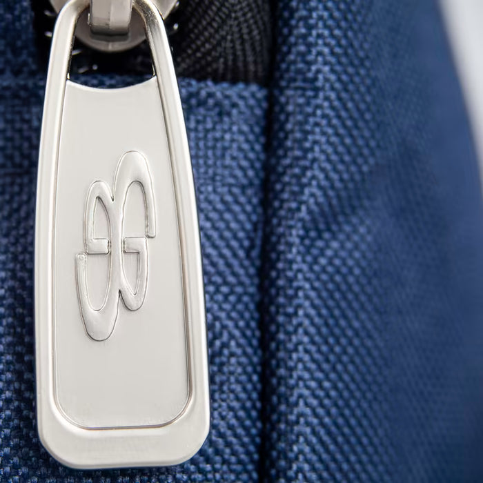 Close-up of a silver zipper pull engraved with a double G logo on blue textured fabric, likely from the Boombah Superpack Bat Bag: BPSP by Boombah.
