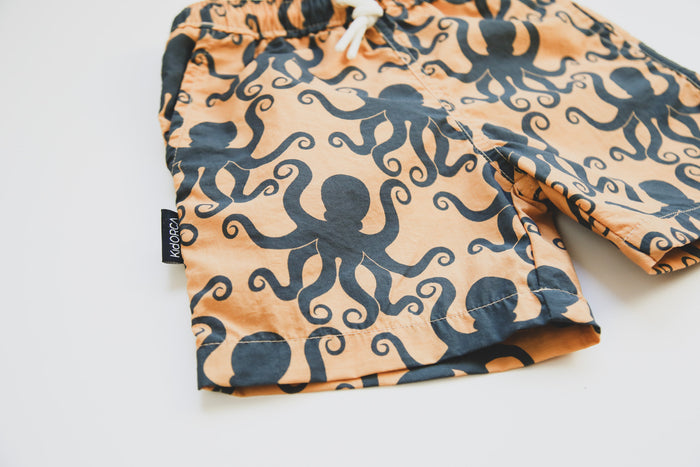 Close-up of quick-dry recycled polyester fabric – octopus desert sand swim trunks