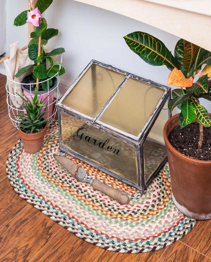 Multi Colored braided rug under a garden box in spring garden shed