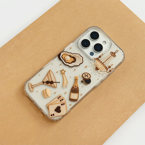 A clear phone case decorated with macron-style graphics of oysters, a cocktail, a champagne bottle, playing cards, and a macaron.