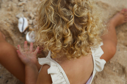 Girl playing in almond waffle weave swimsuit variant by KidORCA