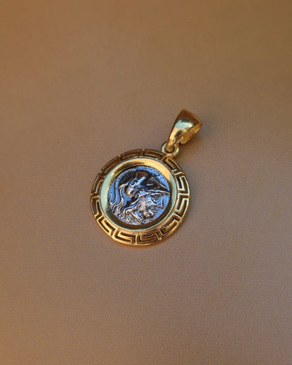 Silver replica ancient Greek coin featuring Athena, the Greek goddess of wisdom wearing a helmet, surrounded by an 18k gold-plated Greek key meander frame. Greek mythology jewelry