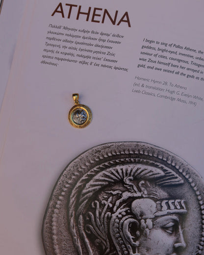 Silver replica ancient Greek coin featuring Athena, the Greek goddess of wisdom wearing a helmet, surrounded by an 18k gold-plated Greek key meander frame. Greek mythology jewelry