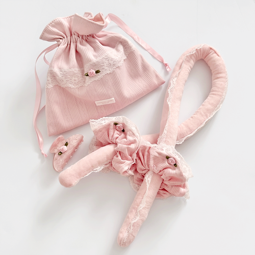 Soft pink heatless curling rod, with matching scrunchies and claw clip. Comes in a pink pointelle fabric storage bag with Coconut Lane logo badge. White lace trim detailing.