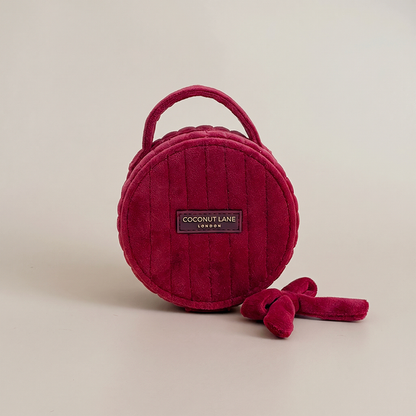 Burgundy velvet jewellery box with a quilted design, top handle, bow detail, and gold-tone hardware.