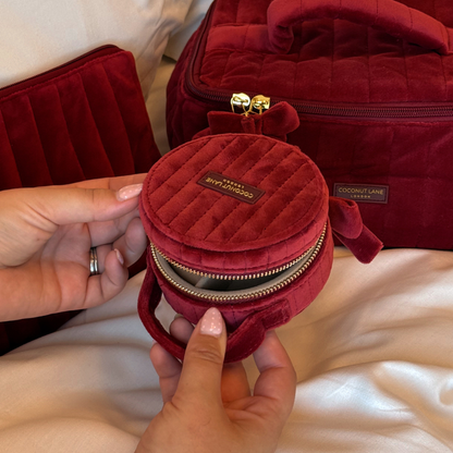 Burgundy velvet jewellery box with a quilted design, top handle, bow detail, and gold-tone hardware.