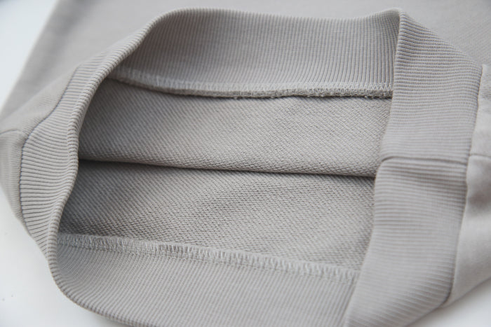 Close-up of soft organic french terry fabric texture – pebble grey kids hoodie