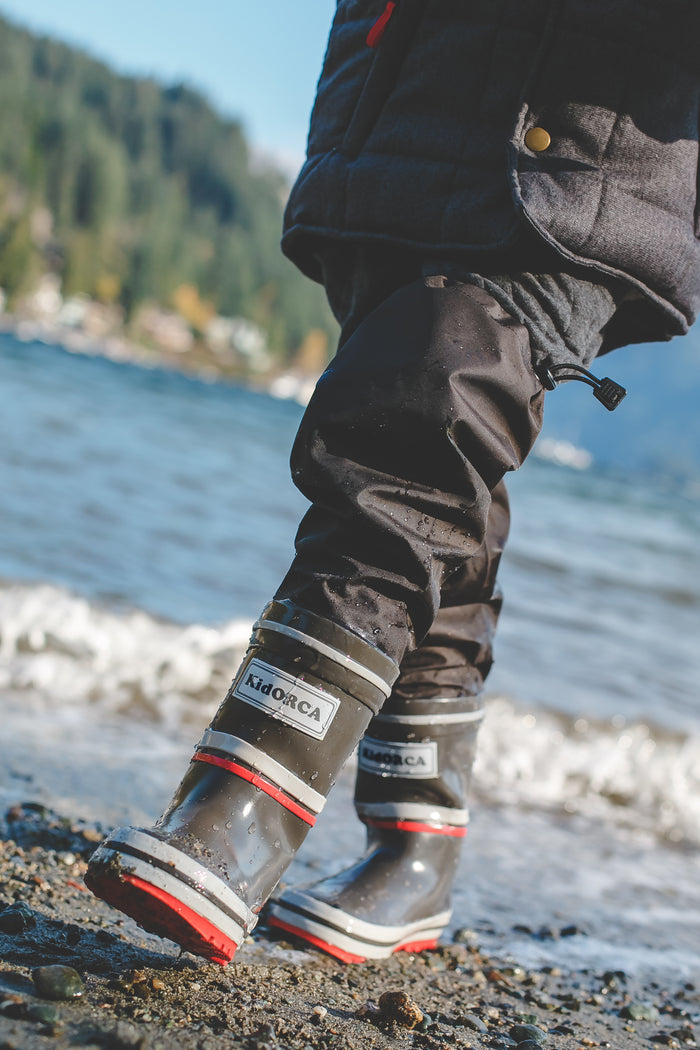 Child wearing grey above-knee rain waders – side view