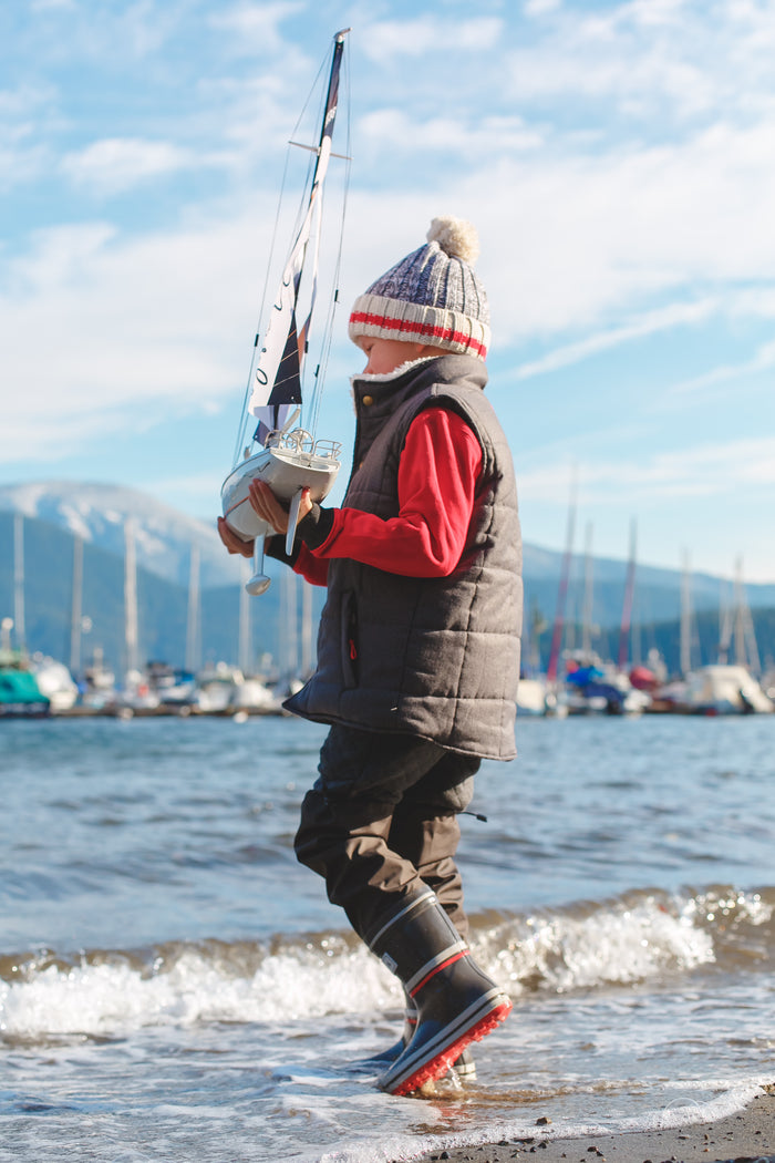 Child wearing grey above-knee rain waders – side view