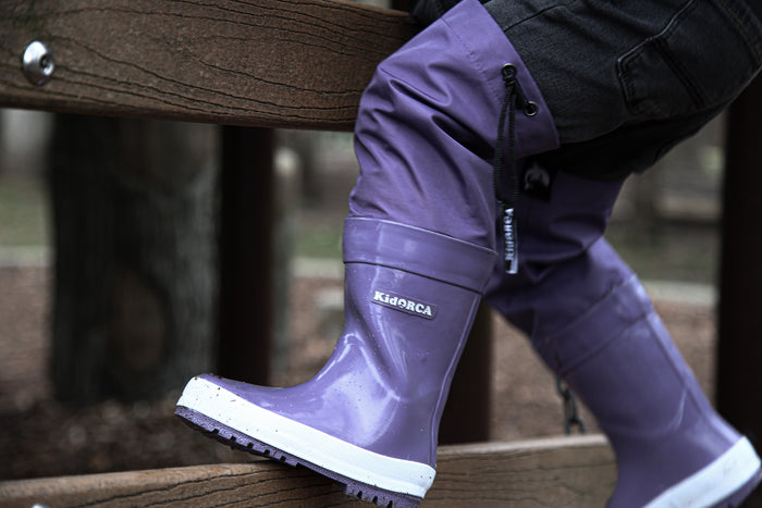 Child wearing grape above-knee rain waders – side view