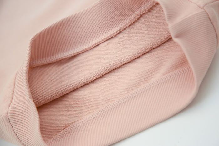 Close-up of organic french terry fabric texture – pale rose kids sweatpants