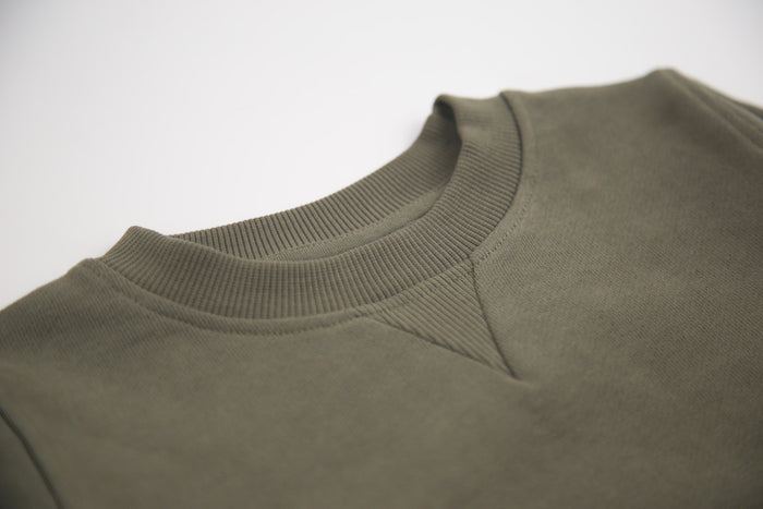 Close-up of french terry fabric and crewneck on dusty olive kids sweatshirt