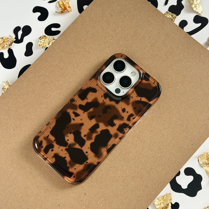 Coconut Lane Leopard Tort phone case with a brown and black tortoiseshell pattern on cardboard background.