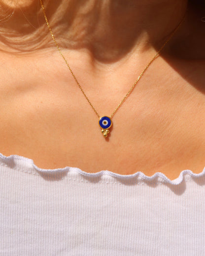 Woman wearing an 18k gold-plated evil eye necklace with a blue murano glass evil eye made in Greece, Greek evil eye jewelry