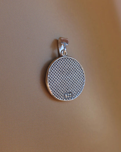 Back side of a silver oxidized pendant with a grid and 925 stamp