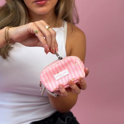 A woman in a white tank top holds a pink striped mini keyring bag. It is decorated with small spicy margarita illustrations.