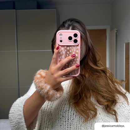 Girl in mirror with brown hair holds a pink and fawn print phone case