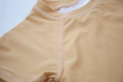 Close-up of UPF 50+ quick-dry recycled polyester – desert sand rashguard