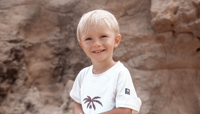 Child playing in palm tree rashguard by KidORCA