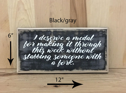 12x6 black/gray funny wood sign with white lettering.