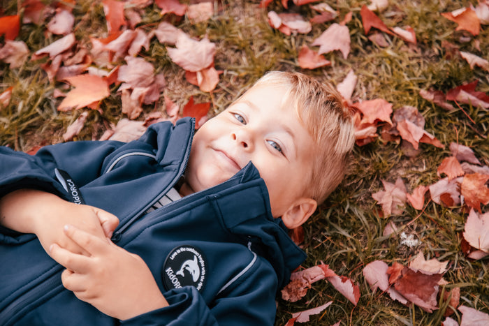 Child wearing navy softshell play suit by KidORCA