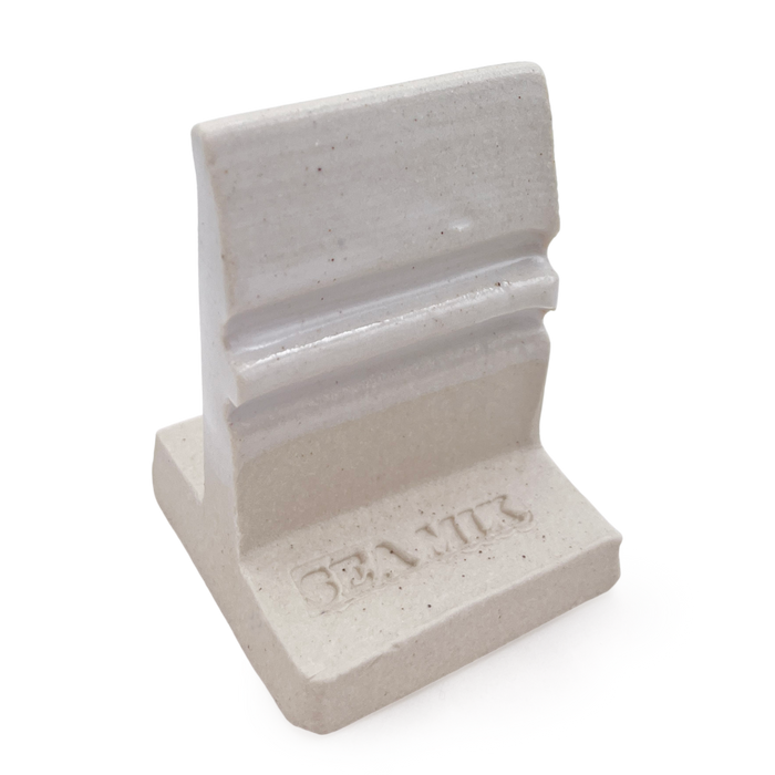 SP32 White Satin glaze on an L-shaped test tile, glossy white on the grooved upright above a bare speckled clay base