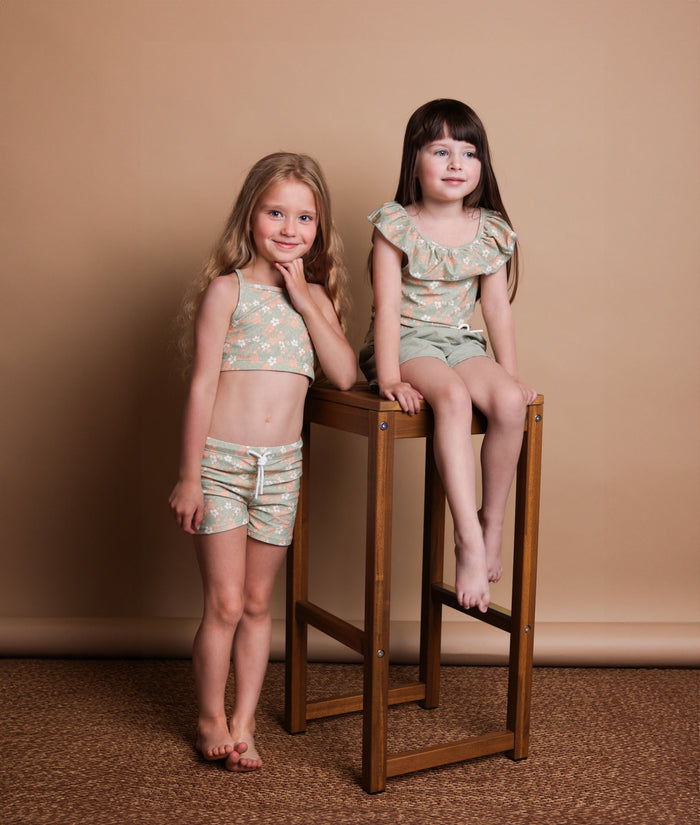 Girl wearing Evangelina sage swim top – side view with adjustable straps