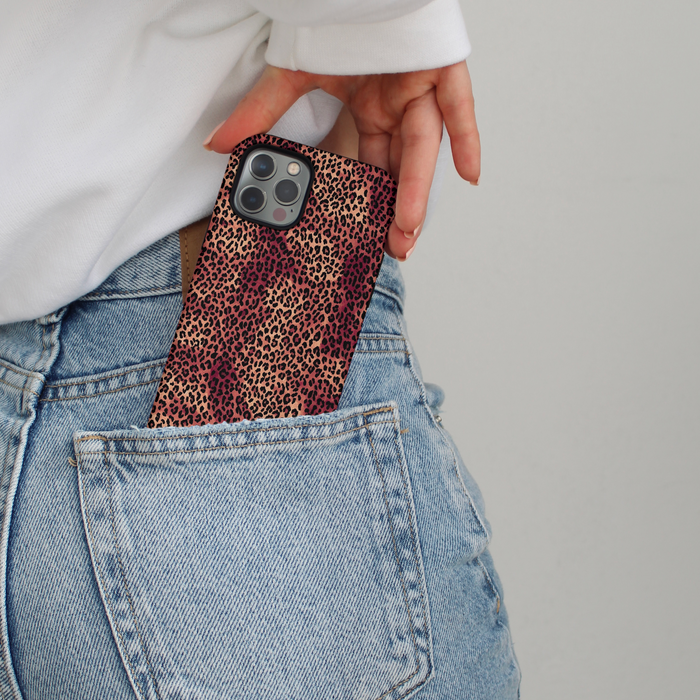 Leopard print Coconut Lane phone case partially tucked into the back pocket of light blue jeans.