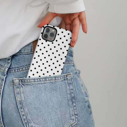 White polka dot MagSafe phone case being slid into the back pocket of blue jeans.